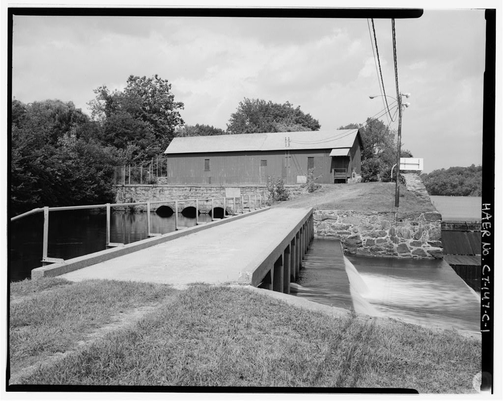 View north, showing bridge across spillway, two levels of aprons; headgates in background