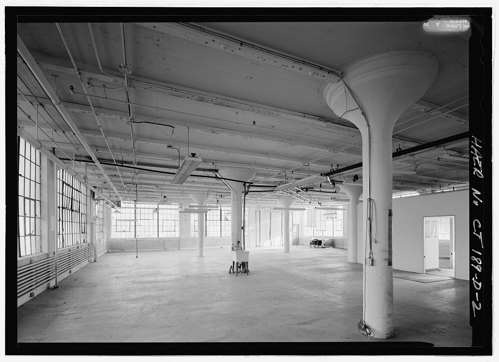 INTERIOR FOURTH FLOOR, SOUTH HALF, LOOKING SOUTH.  NOTE MUSHROOM COLUMNS AND CEILING HAS WOODEN NAILERS. - Colt Fire…